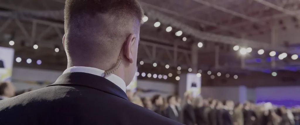 Bodyguard wearing an earpiece at a crowded event