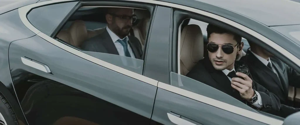 Two executive bodyguards protecting a man in a car